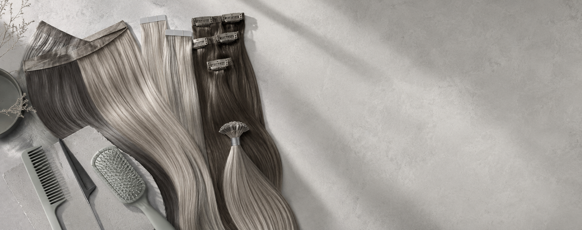 Luxury flat lay of multiple Remy human hair extension methods including weft, tape-in, clip-in, and I-tip pieces on a cool muted green background.